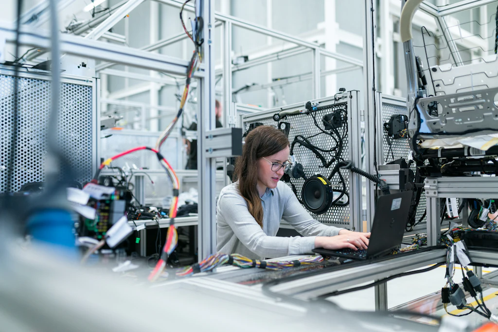 Tecnica al computer accanto a un impianto automatizzato
